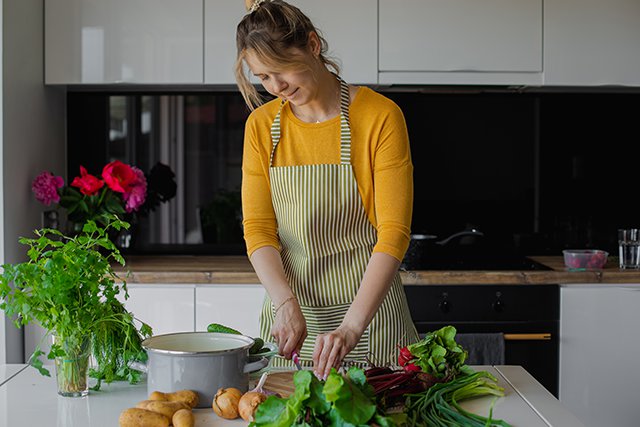 Una-mujer-cortando-verduras-frescas-y-vegetacion-Retos