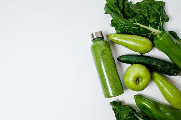 Verduras-y-frutas-verdes-y-una-botella-de-batido-Retos