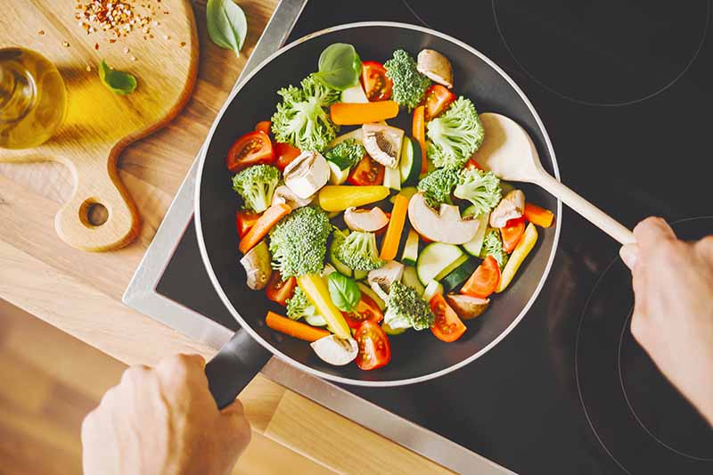 man-cooking-fresh-vegetables-pan