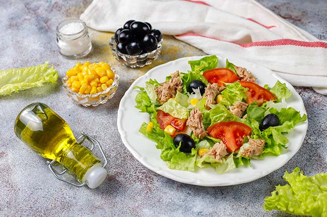 tuna-salad-with-lettuce-olives-corn-tomatoes-top-view